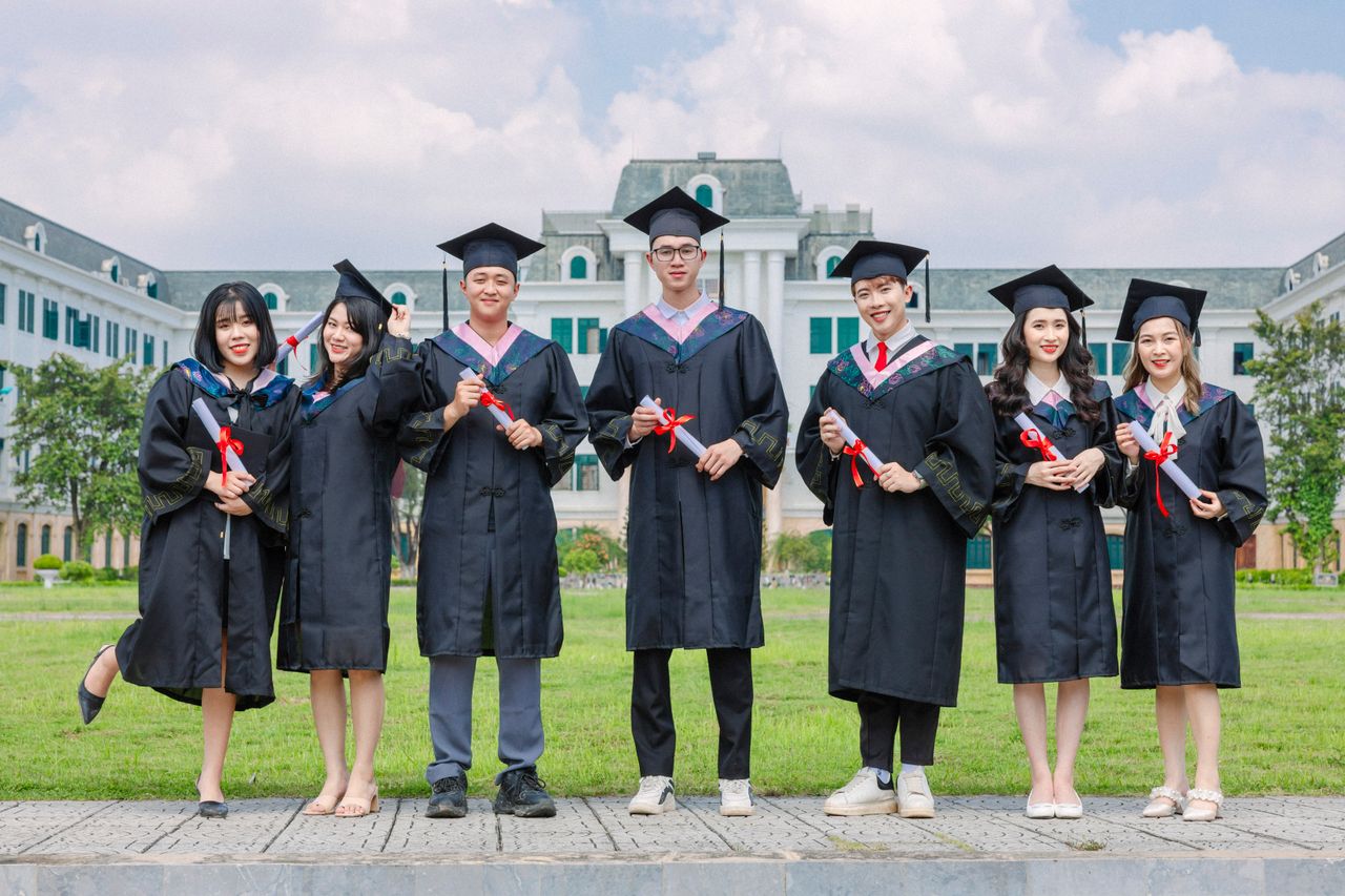 Crafting Captivating Headlines: Your awesome post title goes here Group of diverse young graduates in gowns holding diplomas outdoors in front of a university building.